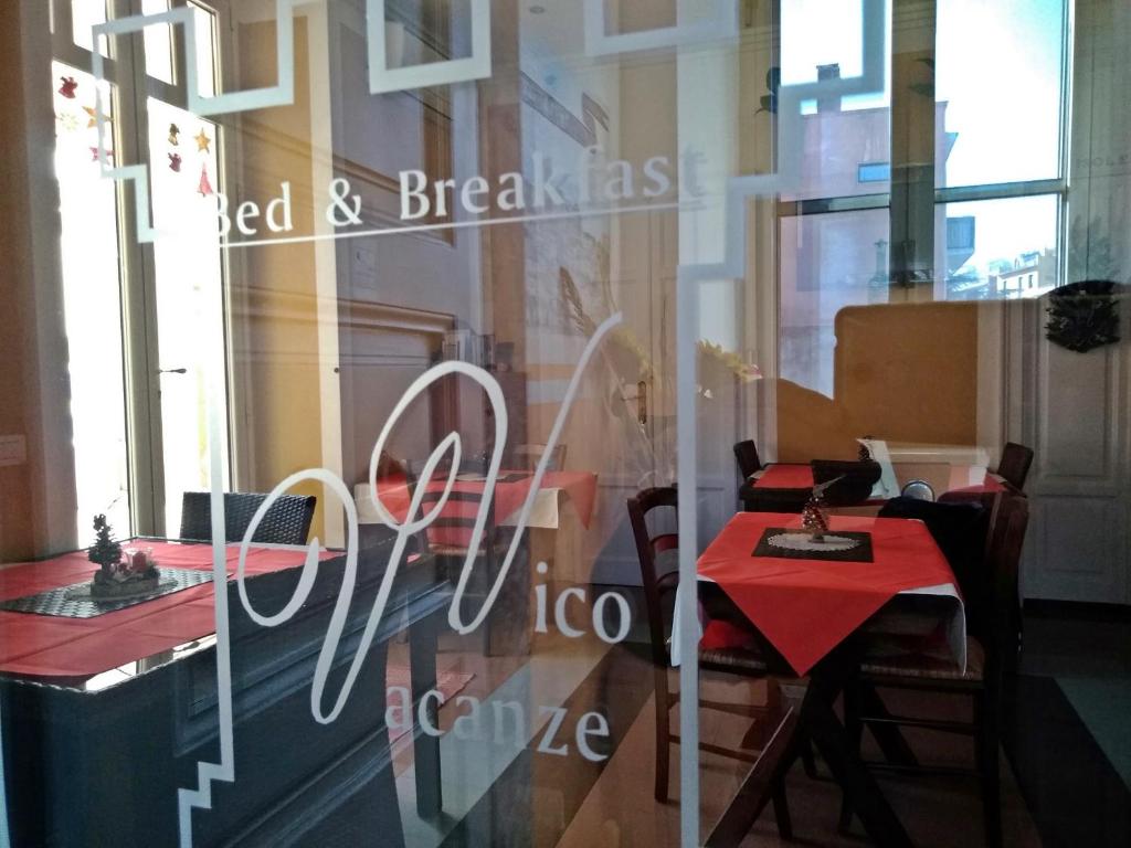 ヴィーコ・デル・ガルガーノにあるB&B Vico Vacanzeの窓に赤いテーブルと椅子が備わるレストラン