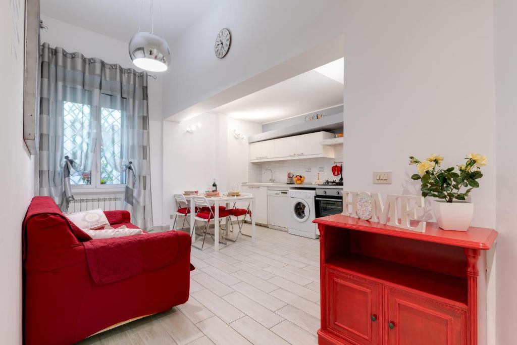 un soggiorno con sedia rossa e una cucina di Trastevere In Love a Roma