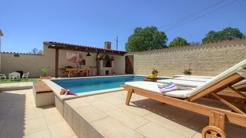 a backyard with a swimming pool and a house at Charming villa Eleonora with pool near Pula in Manjadvorci