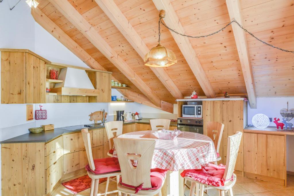 a kitchen and dining room with a table and chairs at Appartamento Maura in Pozza di Fassa
