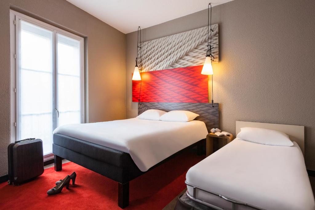 une chambre d'hôtel avec deux lits et deux fenêtres dans l'établissement ibis Marne La Vallee Champs-sur-Marne, à Champs-sur-Marne