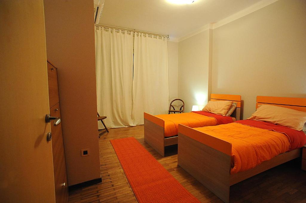 una camera con 2 letti e lenzuola arancioni di Casa Vacanze Helsinore a Sanremo