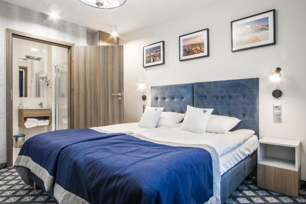 a bedroom with a large bed with a blue headboard at Hotel Urbi in Gdańsk