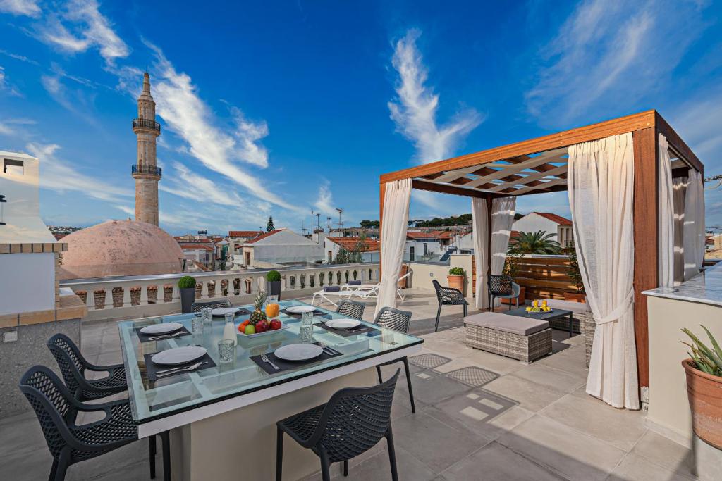 een patio met een tafel en stoelen op een balkon bij StefaniHome in Rethimnon