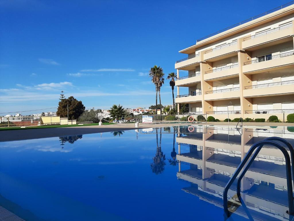 a swimming pool in front of a apartment building at Front Beach Apartment - Quinta da Barracuda in Albufeira