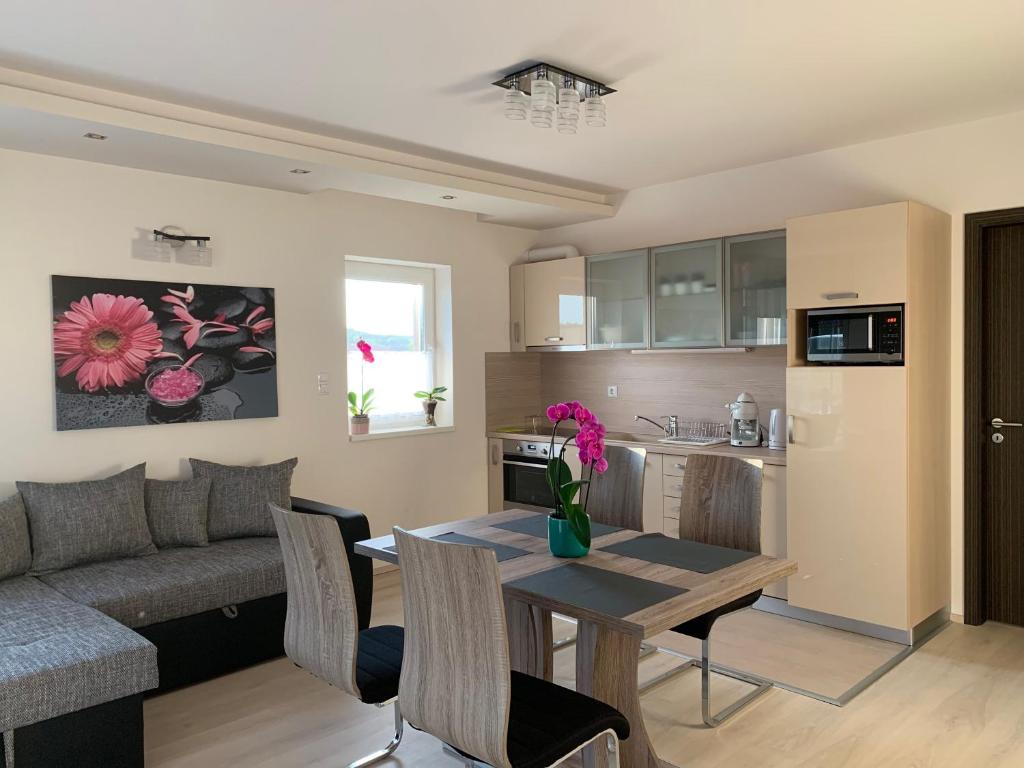 eine Küche und ein Wohnzimmer mit einem Tisch und einem Sofa in der Unterkunft Orchidea Apartmanház Egerszalók in Egerszalók