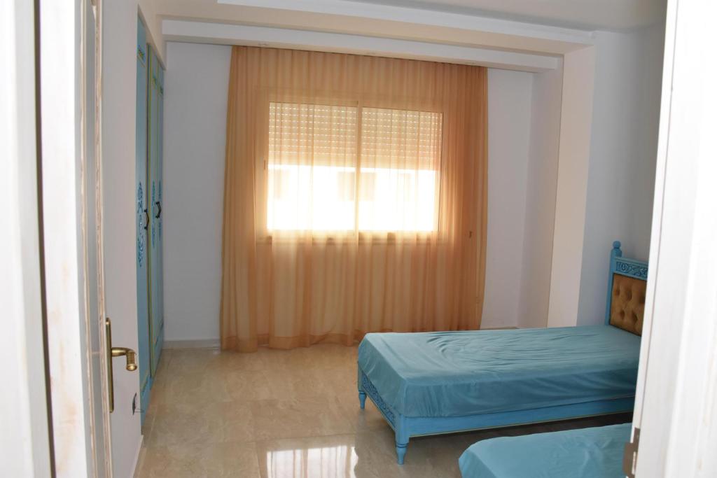 a small room with a bed and a window at Arabesque Style - 2 appartements in Kelibia