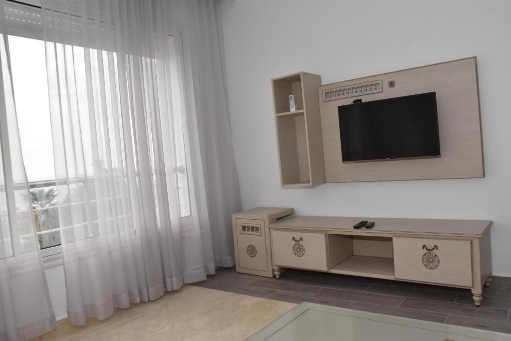 a living room with a tv and a window at Arabesque Style - 2 appartements in Kelibia