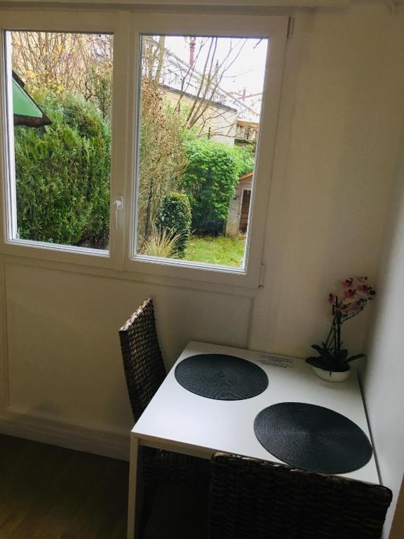 a table and two chairs in a room with a window at Le Tendance : Studio avec Jardin in Courcouronnes