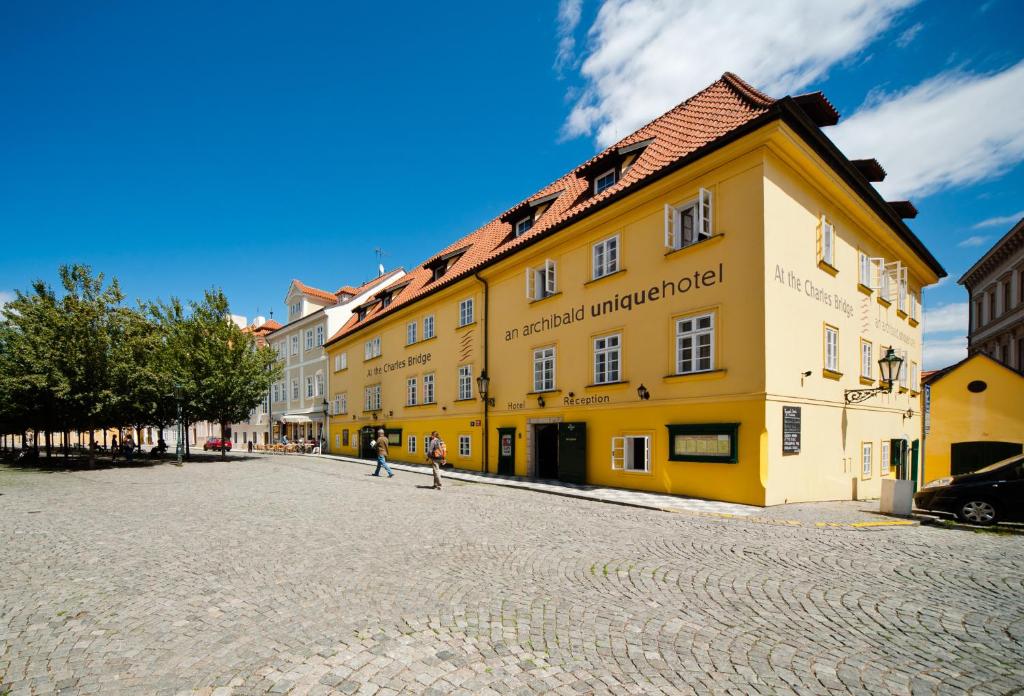 un edificio amarillo al lado de una calle en Archibald At the Charles Bridge, en Praga