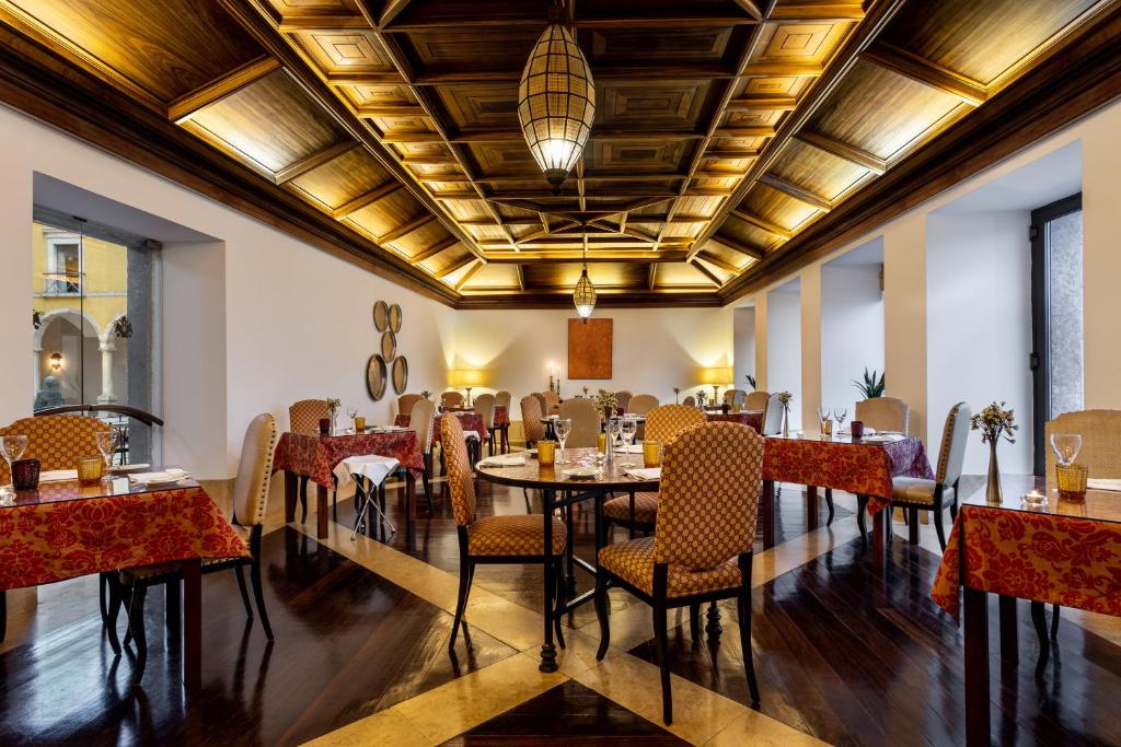 een eetkamer met tafels en stoelen en een plafond bij Pousada Convento de Tavira in Tavira