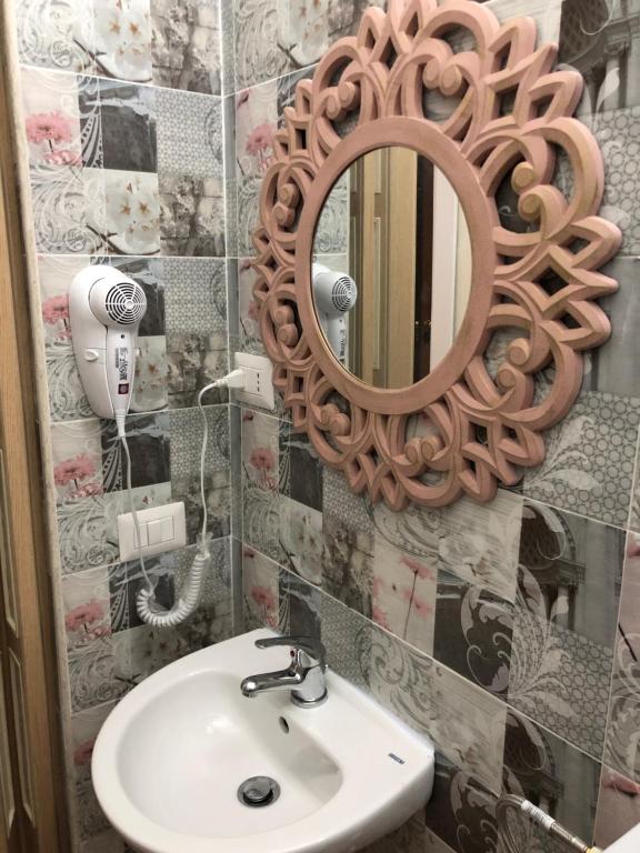 łazienka z umywalką i lustrem na ścianie w obiekcie B&B la reggia w mieście Caserta