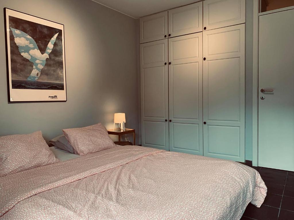 ブレモンにあるAppartement Vallee de la Meuse - Esc'Appartのベッドルーム1室(ベッド1台付)、大きなキャビネットが備わります。
