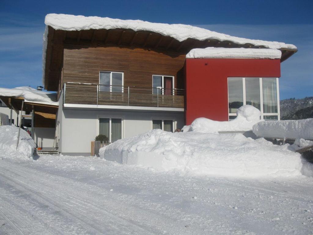 een huis met een berg sneeuw ervoor bij Ferienwohnung Wohlesser in Annaberg im Lammertal