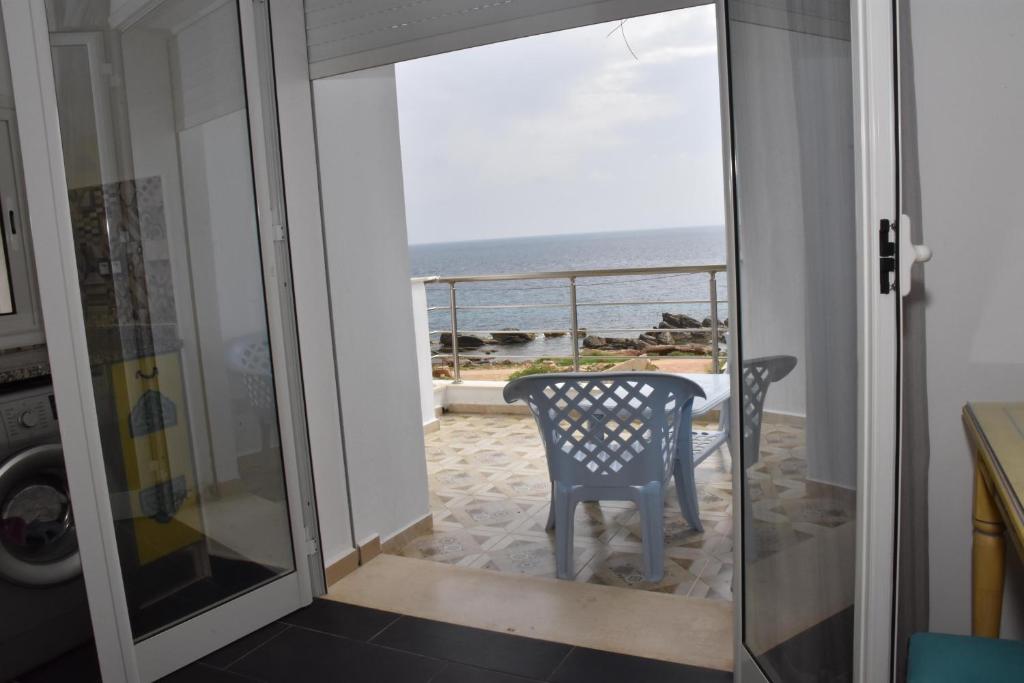 a room with a view of the ocean from a door at Arabesque Style - 2 appartements in Kelibia