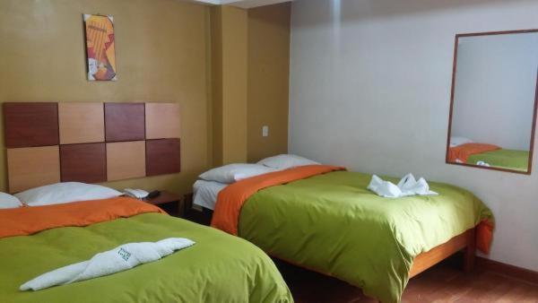 2 camas en una habitación con verde y naranja en Tierra del Inka, en Cusco