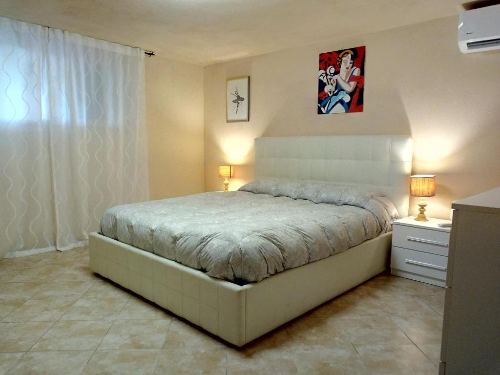 ein Schlafzimmer mit einem Bett, zwei Lampen und einer Kommode in der Unterkunft Il Giardino di Patrizia in Querceta