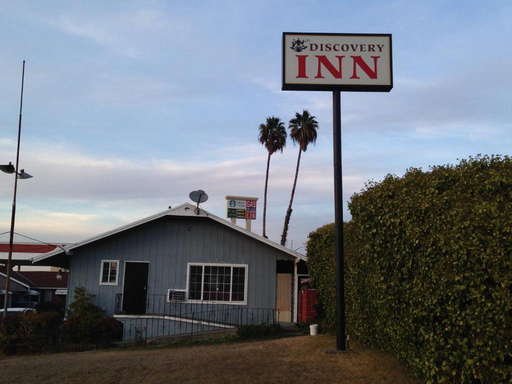 um sinal para uma pousada em frente a uma casa em Discovery Inn em Vallejo