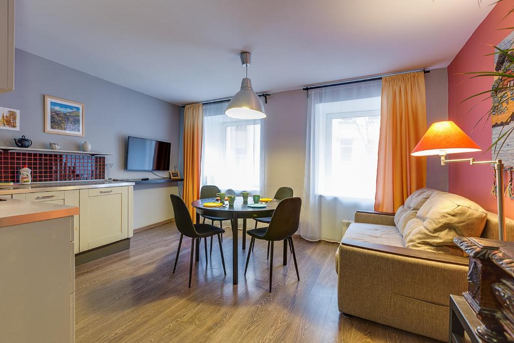 Apartment Griboedova 37 في سانت بطرسبرغ: مطبخ وغرفة معيشة مع طاولة وأريكة
