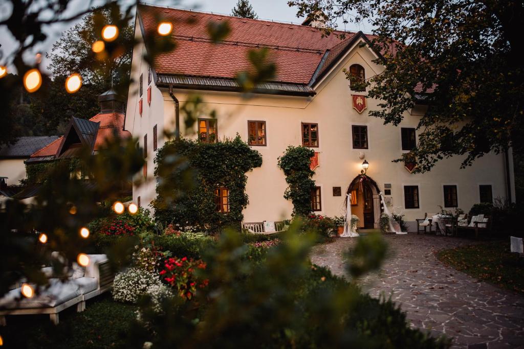 een groot wit huis met een binnenplaats bij Kendov Dvorec in Spodnja Idrija