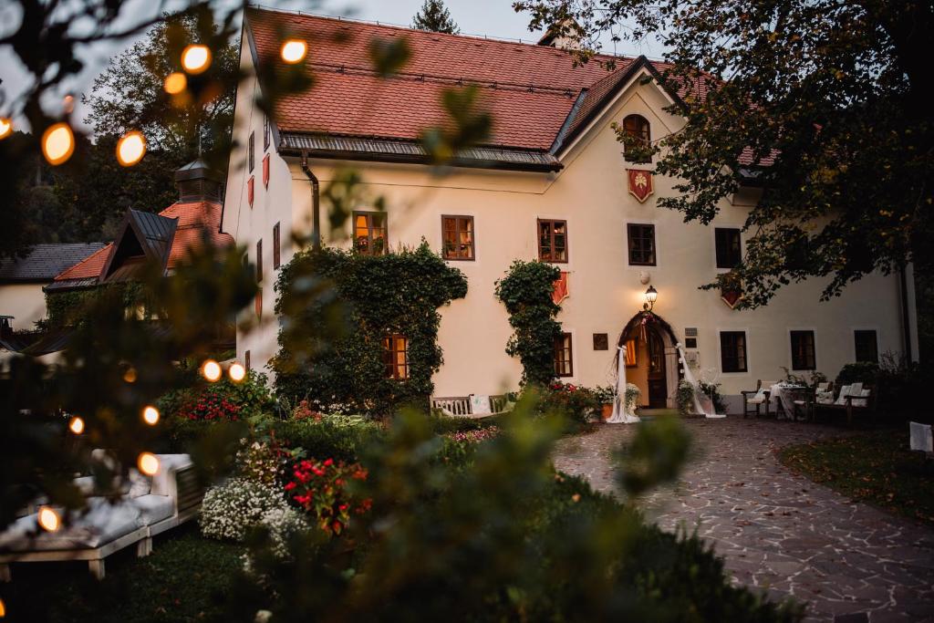 a large white house with a courtyard at Kendov Dvorec in Spodnja Idrija