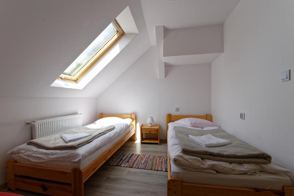 two twin beds in a room with a window at Agroturystyka Burylowka in Osiecznica