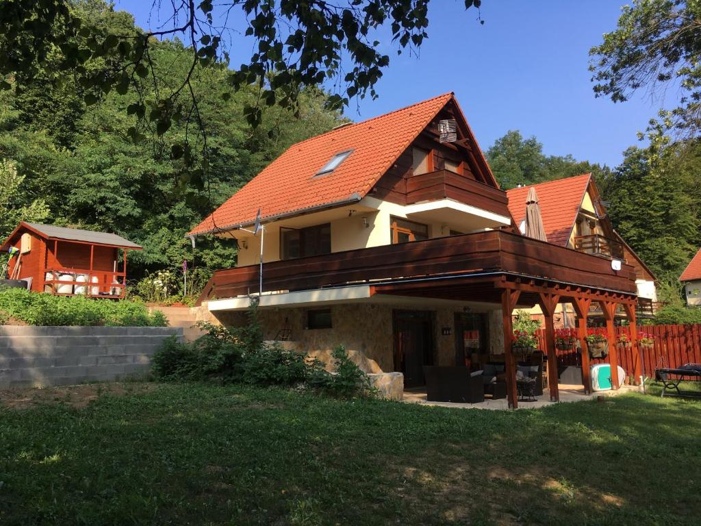 a house with an orange roof and a yard at Beach House Orfű in Orfű