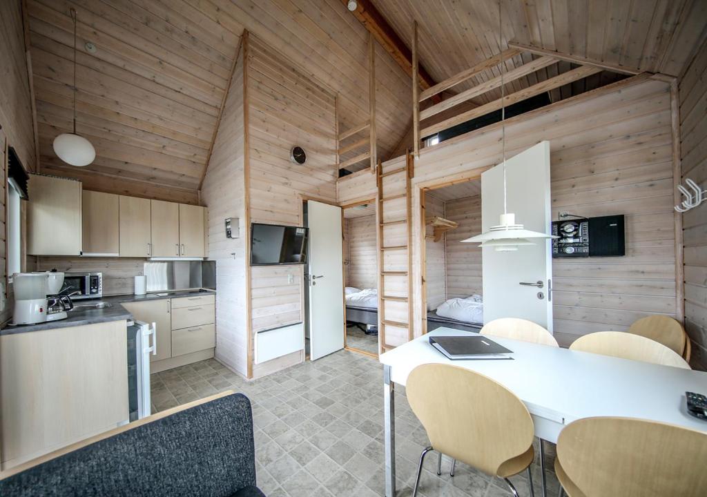 una cucina e una sala da pranzo con tavolo e sedie di Thyborøn Cottages a Thyborøn