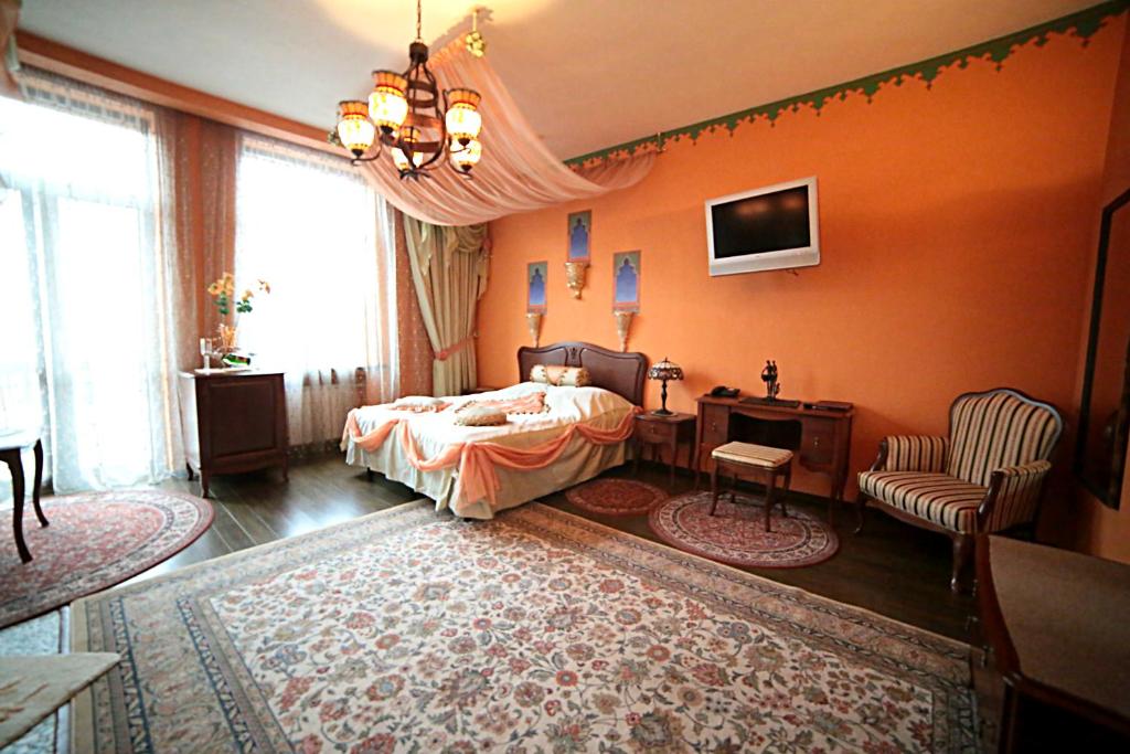 a bedroom with a bed and a desk and a tv at Postoyalets Hotel in Odintsovo