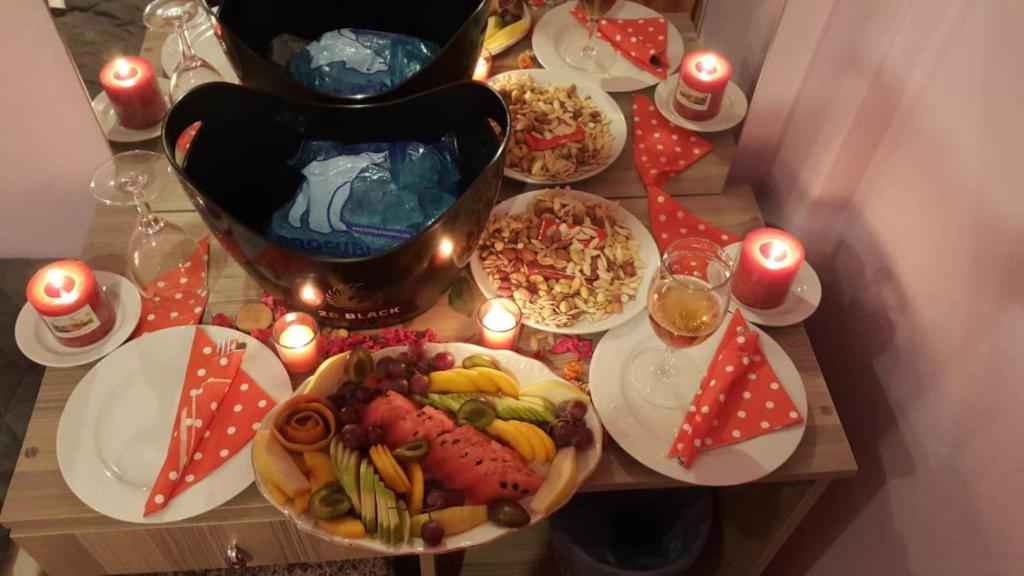 a table topped with plates of food and candles at Grand Yayla Hotel in Çeşme