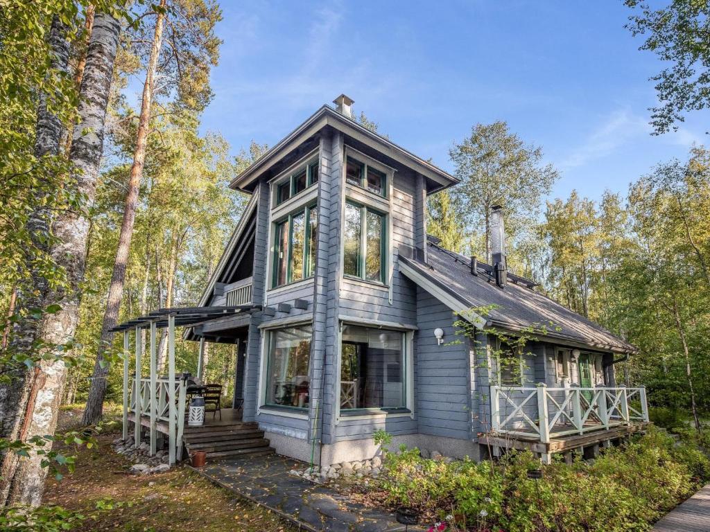 a blue house in the middle of the forest at Holiday Home Villa populus by Interhome in Pertunmaa