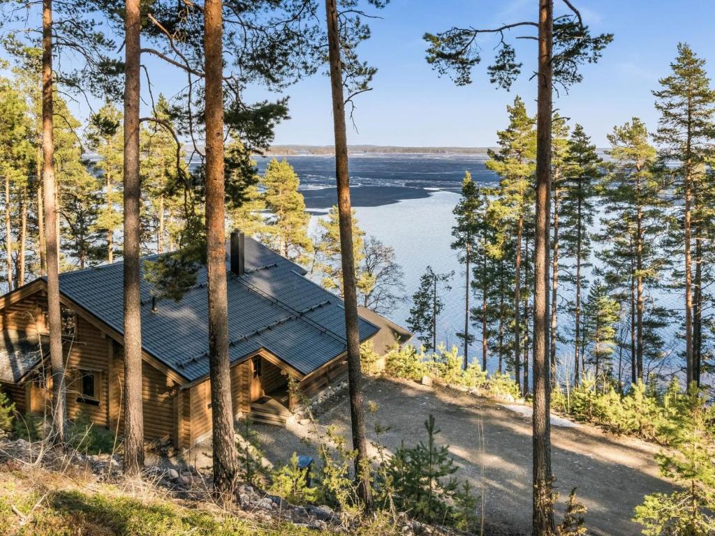 a cabin in the woods with a view of the water at Holiday Home Roopenranta by Interhome in Asikkala