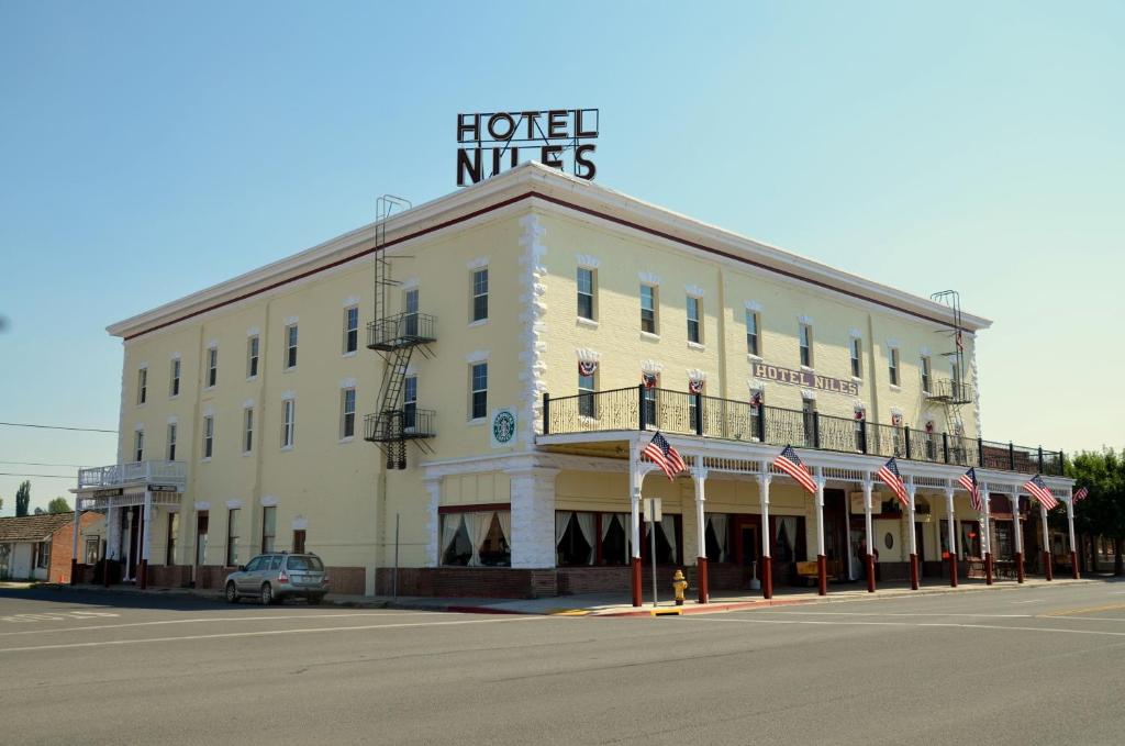 un gran edificio blanco con un cartel encima en Hotel Niles en Alturas