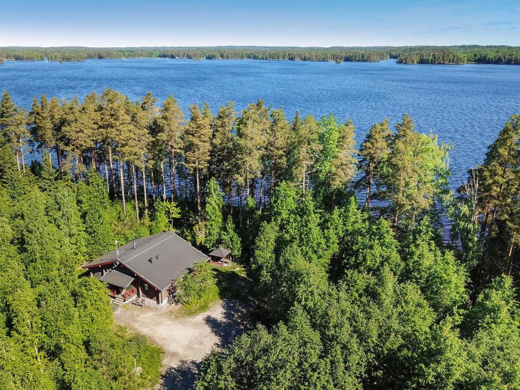 an aerial view of a house in the woods next to a lake at Holiday Home Villa salix by Interhome in Mäntyharju