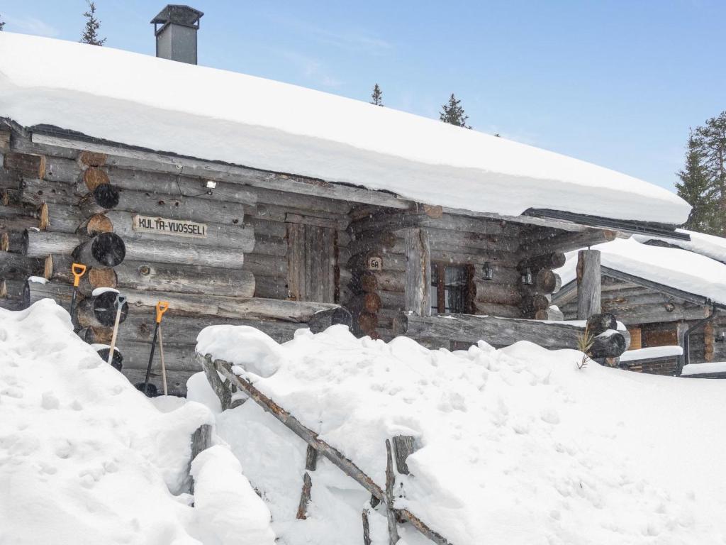 une cabane en rondins recouverte de neige devant elle dans l'établissement Holiday Home Kulta-vuosseli a by Interhome, à Ruka