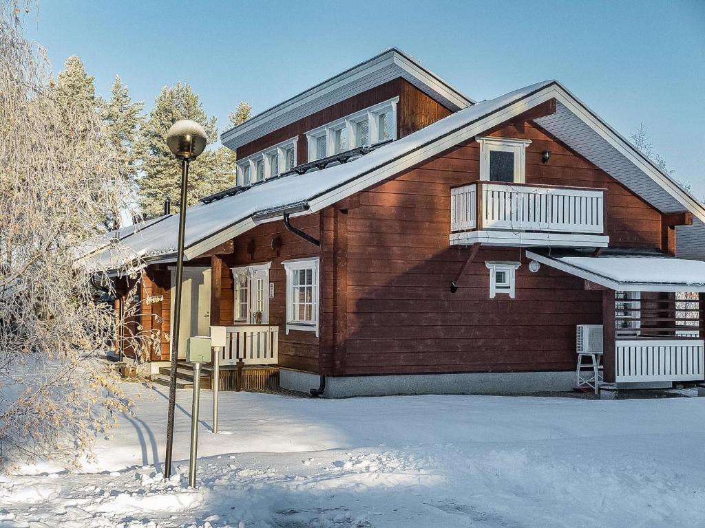 a wooden house in the snow with a balcony at Holiday Home Lepolinna b by Interhome in Tahkovuori