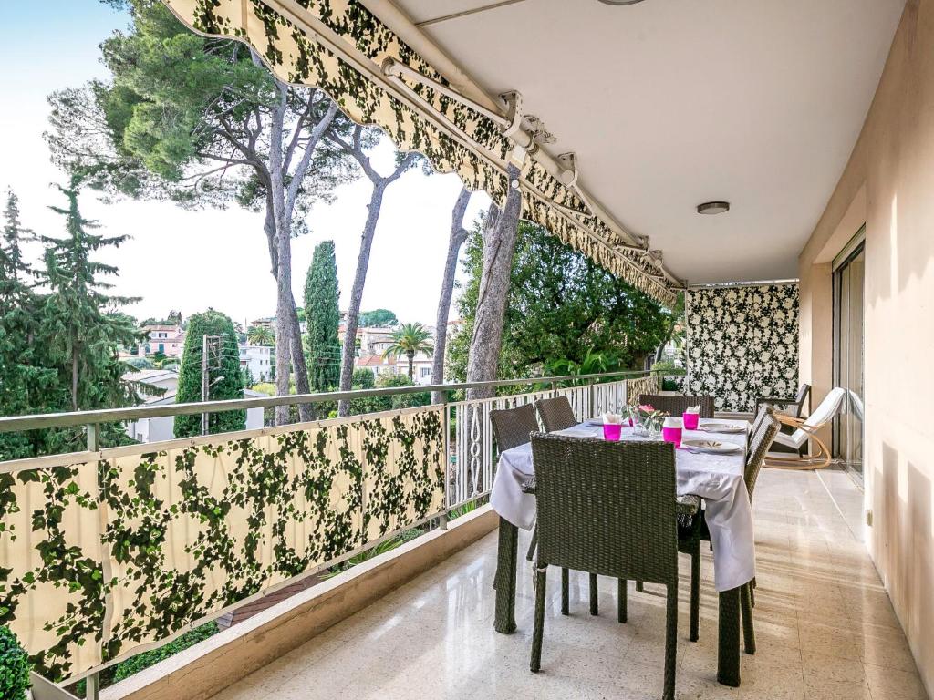 a balcony with a table and chairs on a balcony at Apartment Les Pins D&#39;Alep by Interhome in Le Cannet