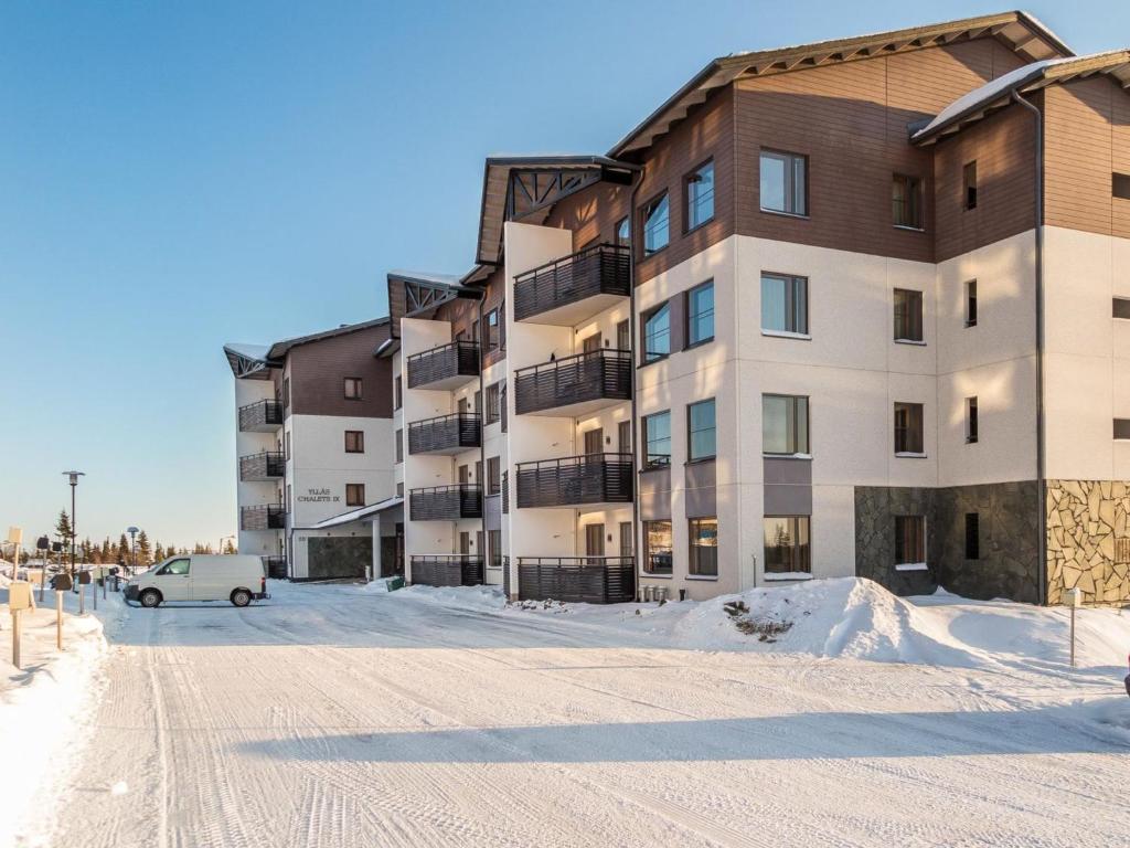 ein Apartmenthaus im Schnee mit einem Auto vor dem Haus in der Unterkunft Holiday Home Nordic chalet 9209 by Interhome in Ylläsjärvi