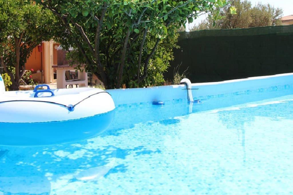 uma piscina com um barco na água em Vravrona Sea View Country House near Athens em Vravrona