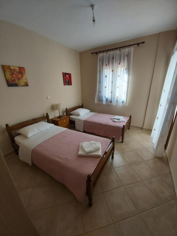 a hotel room with two beds and a window at Casa Louli in Syvota