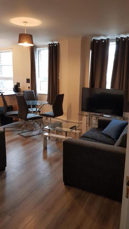 sala de estar con sofá, sillas y mesa en Atlantic Mansions 2 Bedroom Split Level Apartment en Southampton