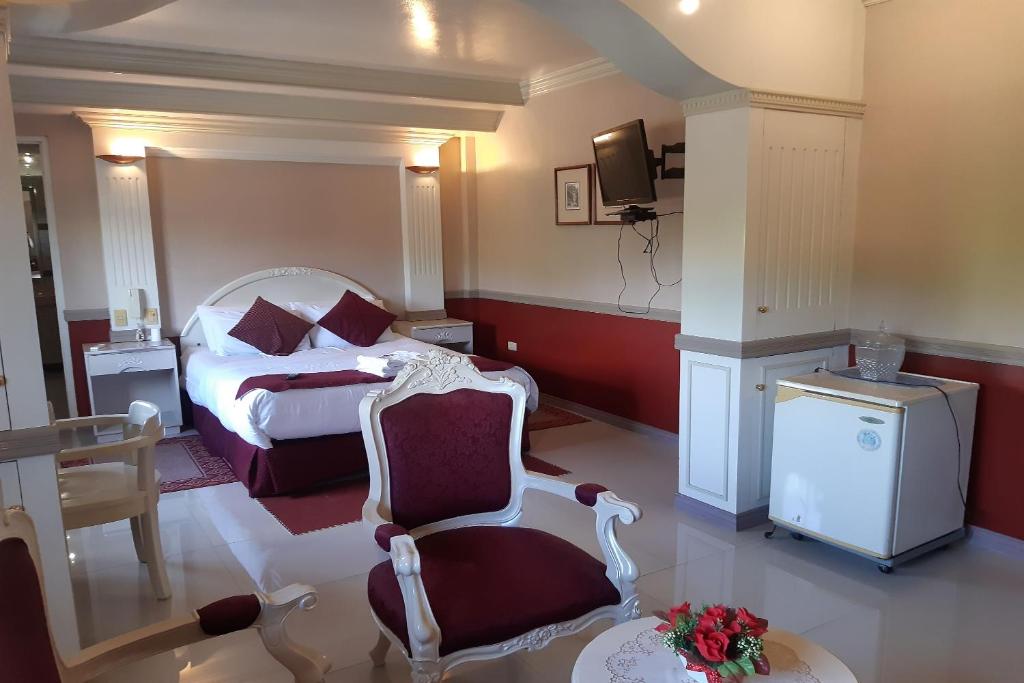 Habitación de hotel con cama y silla en SM Travelodge, en Batangas
