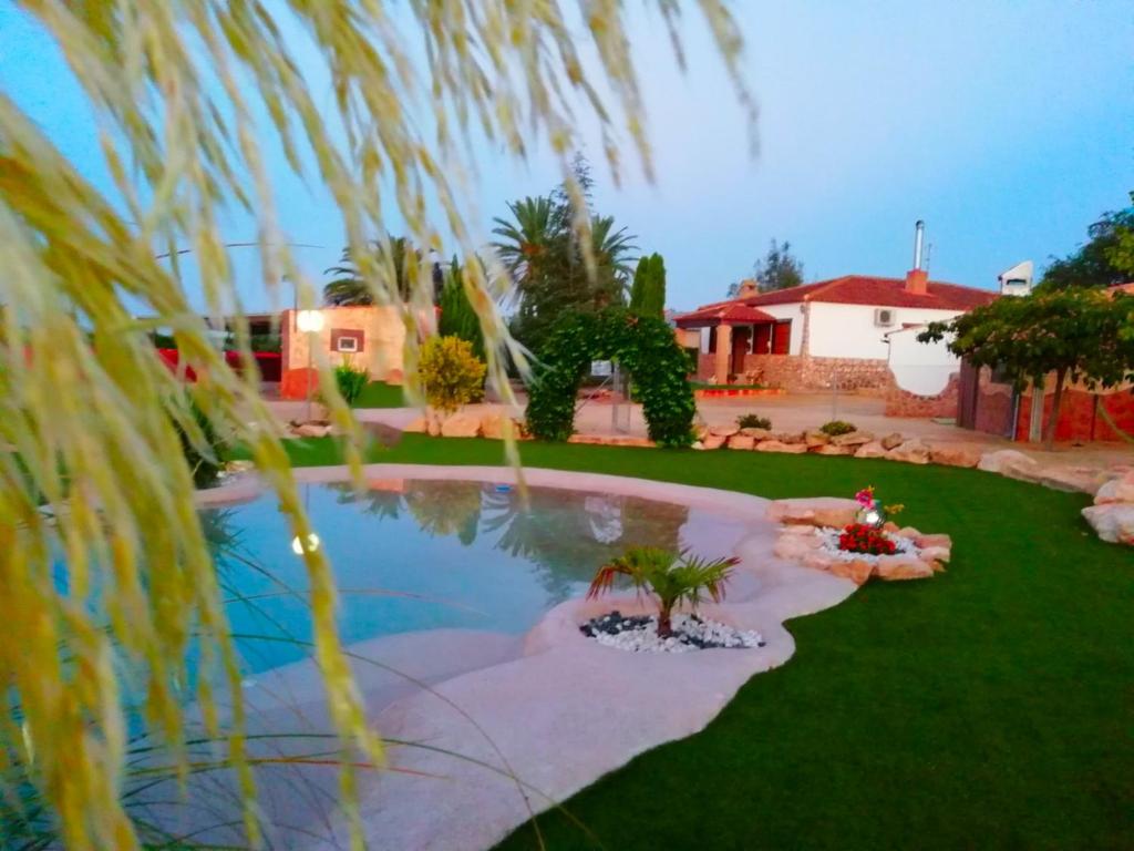 un patio con piscina y una casa en CASA RURAL LAS PALMERAS en Tobarra