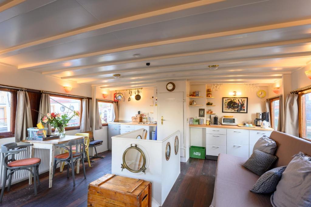 Boatapartment Animathor on top location في روتردام: غرفة معيشة ومطبخ في منزل صغير