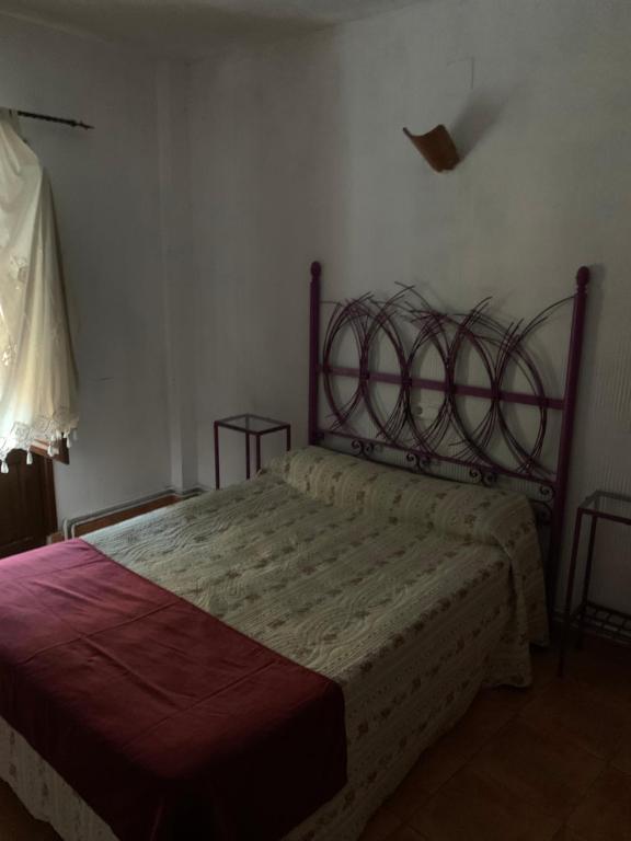 a bedroom with a bed with a metal headboard at Hostal Calderon Cuenca in Cuenca