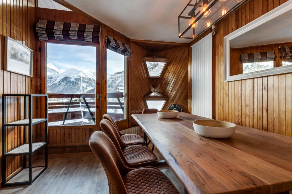 a dining room with a table and chairs and a window at Le Santel 199 in Val-d'Isère