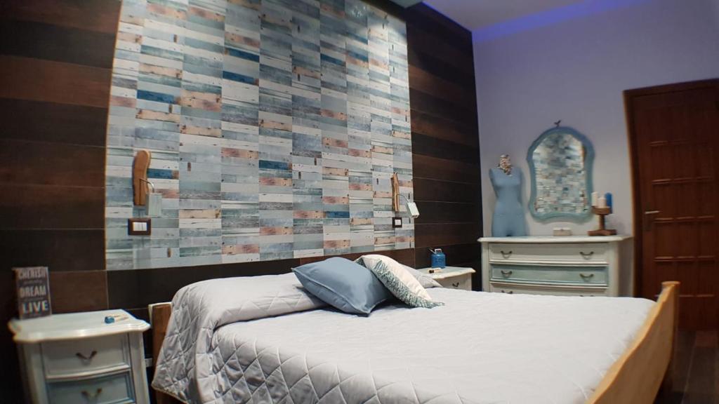 een slaapkamer met een bed en een muur met tegels bij B&B Ammore in Castellammare di Stabia