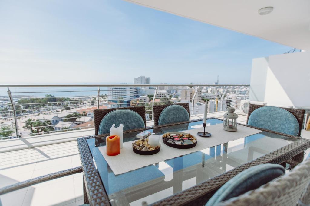 een eettafel op een balkon met uitzicht op de stad bij Promenade Seaview Heaven in Larnaka