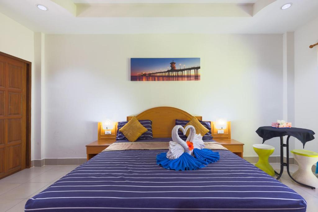 a bedroom with a bed with two swans on it at Grand View in Patong Beach