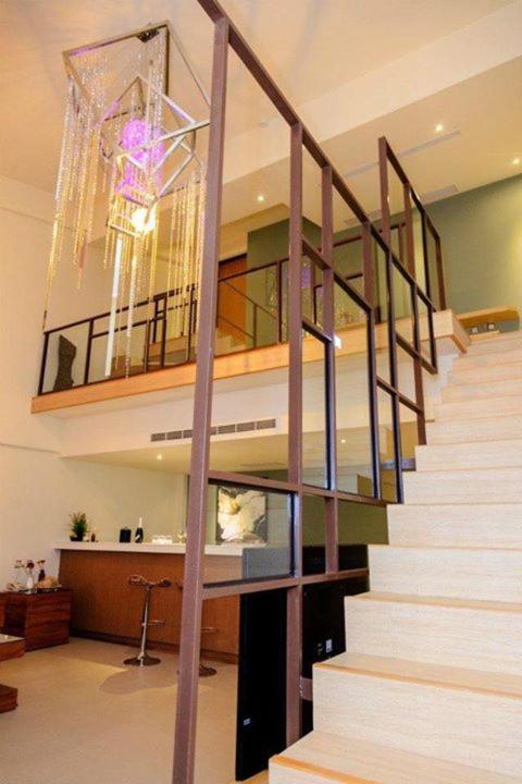 a staircase in a living room with a chandelier at Sheng Tu Villa in Hengchun South Gate